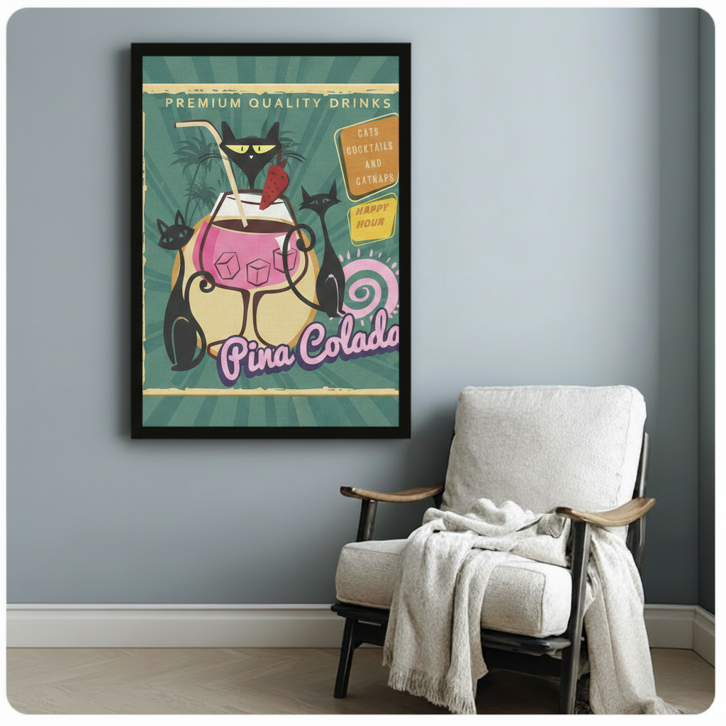 Black framed retro bar poster art print with three black cats and a Pina Colada cocktail glass, styled beside a white armchair against a soft blue-gray wall