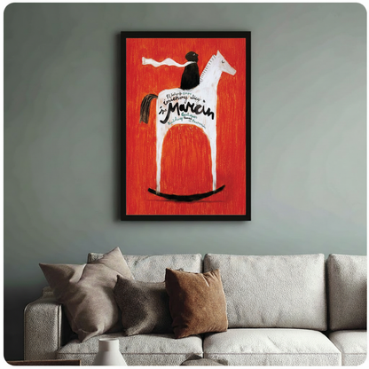 Framed vintage Polish art poster print showing black rider on white rocking horse with bold red background and handwritten Marcin typography, displayed above linen sofa in sage green living room