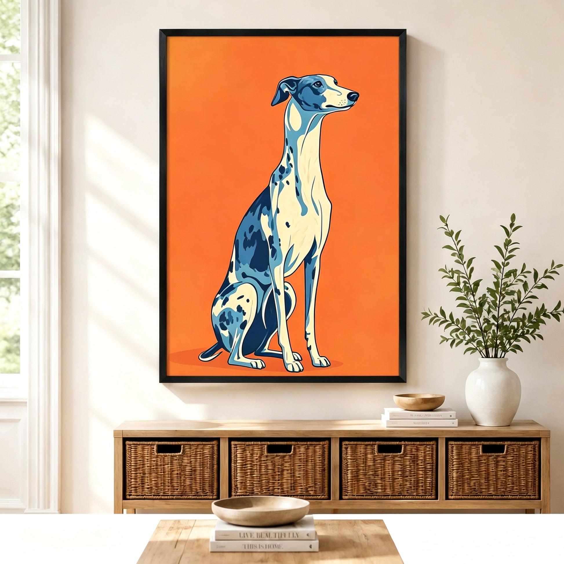 Pop art style blue and white greyhound sitting portrait black framed canvas art on bold orange background above a rattan sideboard with wicker baskets, stacked books, and a white ceramic vase in a Scandinavian living room