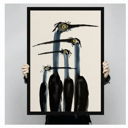Person in black clothing holding large framed canvas print of four staring long-necked birds on cream background