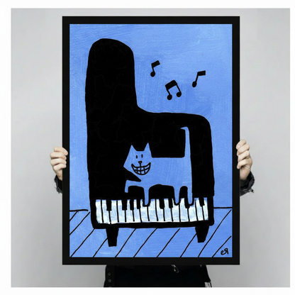 Person holding a large black framed funny cat playing piano canvas art print showing a grinning white cat seated on an abstract black grand piano with expressive music notes against a striking cobalt blue textured background