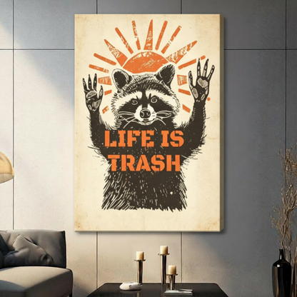 Gallery wrap stretched canvas of a vintage woodcut-style raccoon raising both hands with a resigned expression under a bold orange rising sun and Life Is Trash stencil lettering retro humor illustration on distressed cream paper texture hung frameless on a gray tile wall above a dark sofa