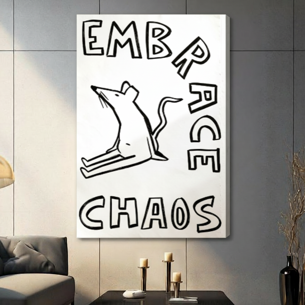Gallery wrap stretched canvas of a bold outline white rat with mouth open in a frantic pose surrounded by chunky hand-lettered Embrace Chaos text minimalist humor illustration on a clean white background hung frameless on a gray tile wall above a dark sofa with metal candlesticks