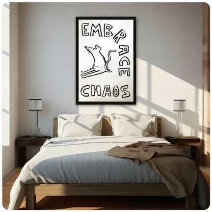 Black framed funny minimalist rat in a wild chaotic pose with bold black outline and Embrace Chaos hand-lettered text humor canvas wall art on white background hung in bright diagonal sunlight above a dark wood bed with white linen bedding and matching wood nightstands