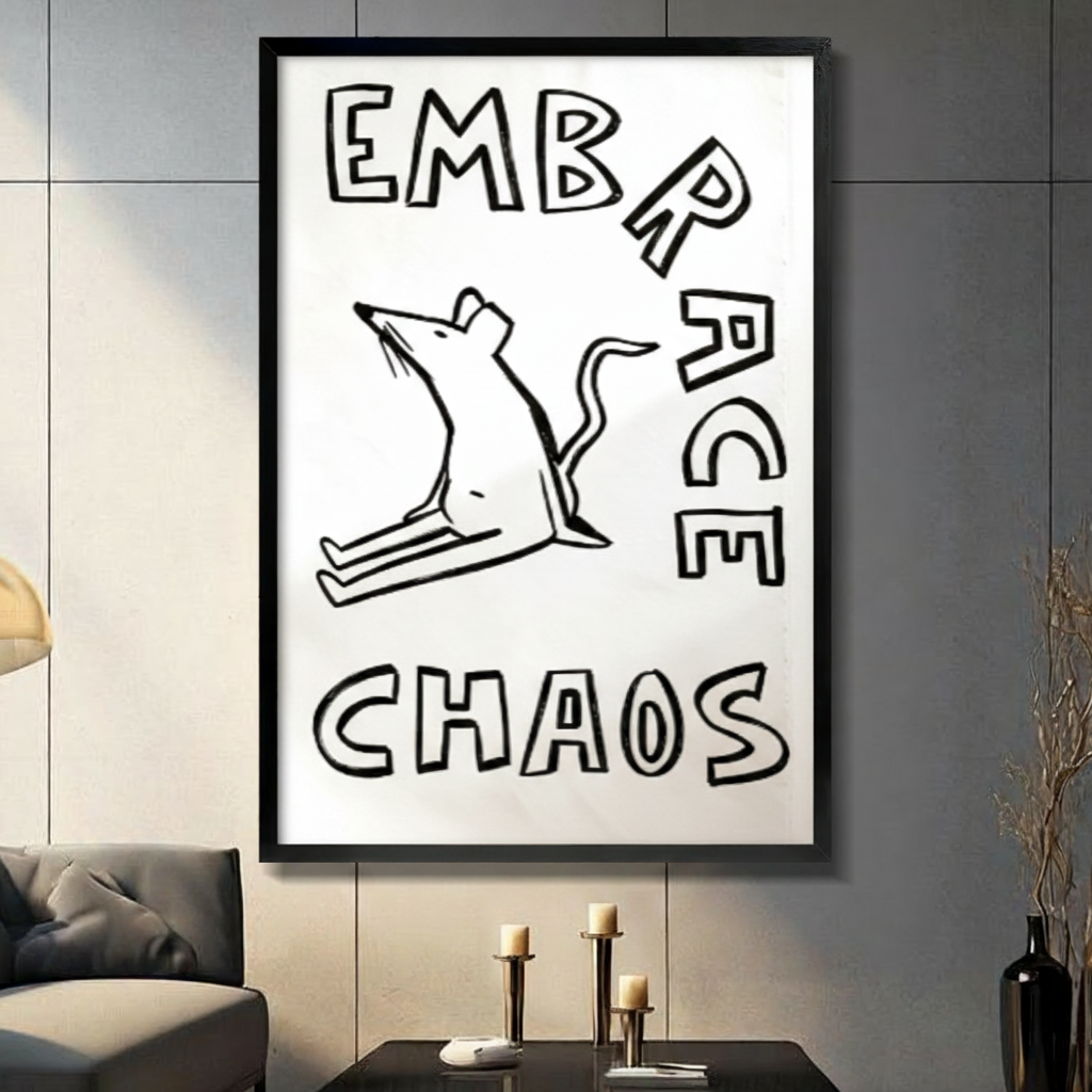 Black framed minimalist black and white hand-drawn rat in a chaotic pose with bold Embrace Chaos hand-lettered text humor poster canvas wall art on white background displayed in a modern gray living room with dark sofa black coffee table and metal candlestick holders