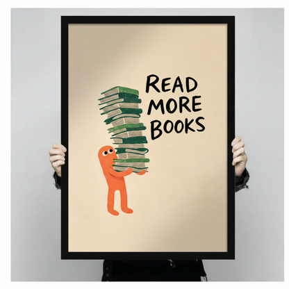 Read More Books framed poster held up against gray background showing full print with orange cartoon character carrying tall stack of green books, black frame close-up