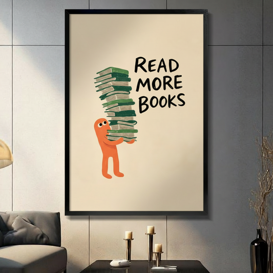 Read More Books framed wall art print displayed in modern living room above candle holder table, black frame, beige background with orange cartoon character holding stack of green books
