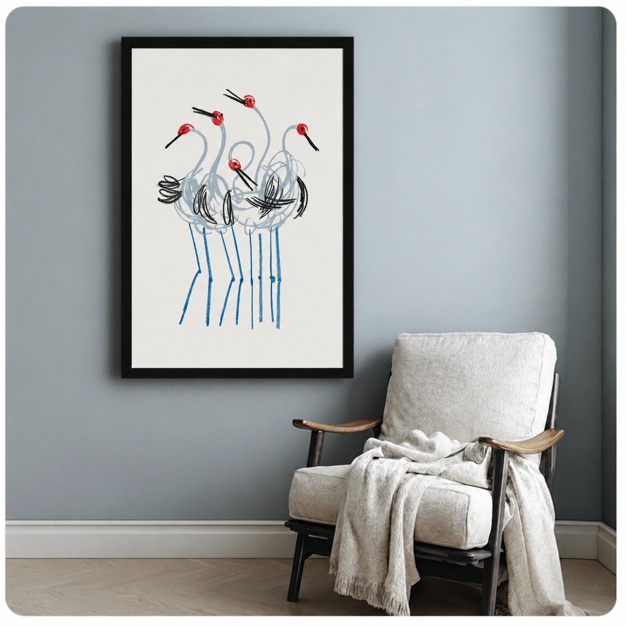 Red crown crane group framed poster print beside accent chair on blue-grey wall, elegant line drawing bird art for modern home