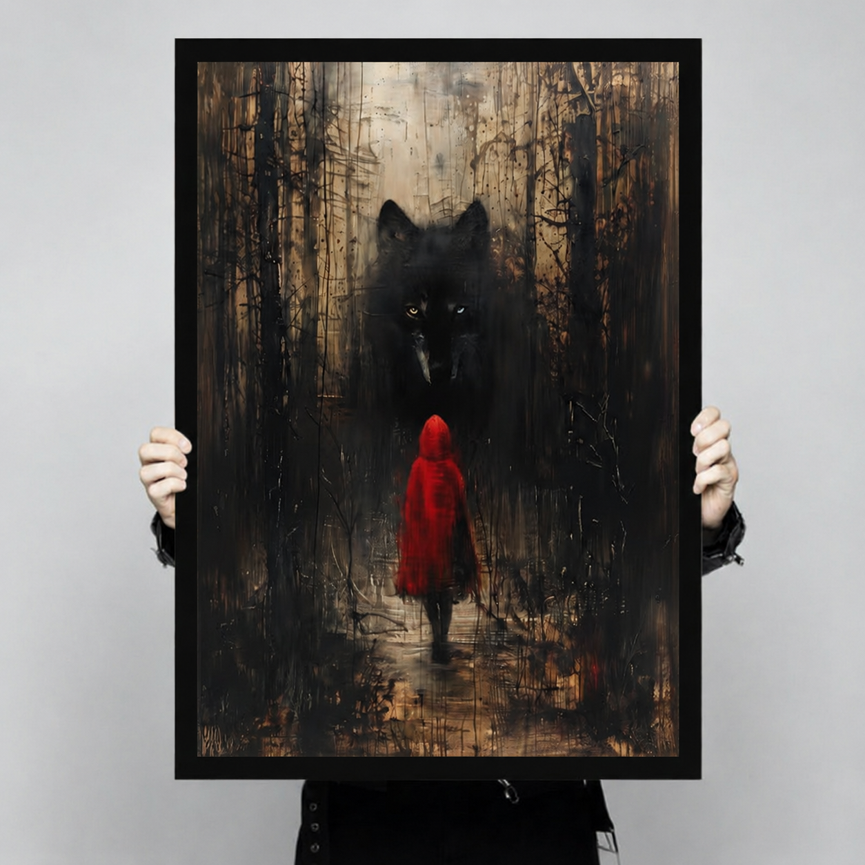 Close-up of dark fantasy art print showing Red Riding Hood and a menacing black wolf in a moody forest, held in hands to show print quality