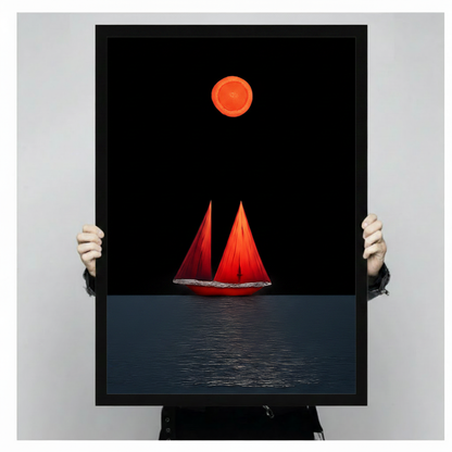 Hand-held display of a black-framed canvas art print featuring a dramatic minimalist red sailboat with twin sails beneath a glowing orange moon on a deep black ocean — bold nautical wall art