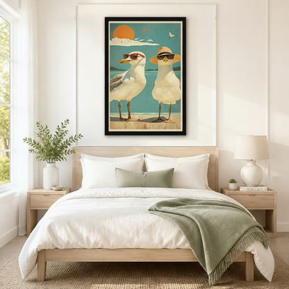 Retro beach seagulls in sunglasses framed canvas wall art hung above bed in a serene coastal bedroom with light wood furniture and sage green bedding
