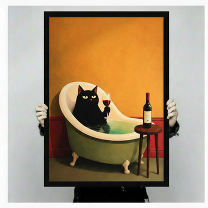 Person holding a large vertical black framed retro black cat drinking wine in a bathtub canvas art print showing a poised black cat lounging in a teal clawfoot tub with a glass of red wine and a bottle on a wooden stool against a warm orange and red background in a light gray studio setting