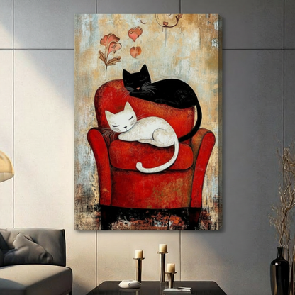 Stretched canvas wall art of a sleepy white cat nestled in a vibrant red armchair with a black cat curled protectively on the backrest, surrounded by drifting pink hearts and botanical sketches on a textured vintage amber background, hung on a gray tile wall beside a modern charcoal sofa