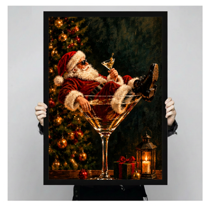 Hands holding black framed Christmas wall art featuring Santa reclining in a giant martini glass.