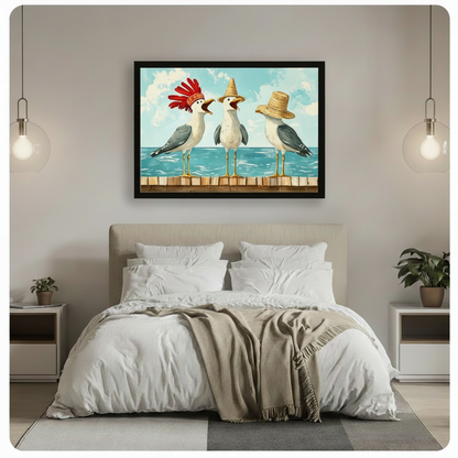 Black framed cheerful coastal canvas wall art of three seagulls standing side by side on a wooden dock railing one with a vibrant red feather headdress one with a tall yellow straw hat and one with a wide-brim straw hat all squawking and animated against a bright blue ocean and cloudy sky funny seagull humor illustration hung above a beige upholstered bed with white linen bedding and glass globe pendant lights