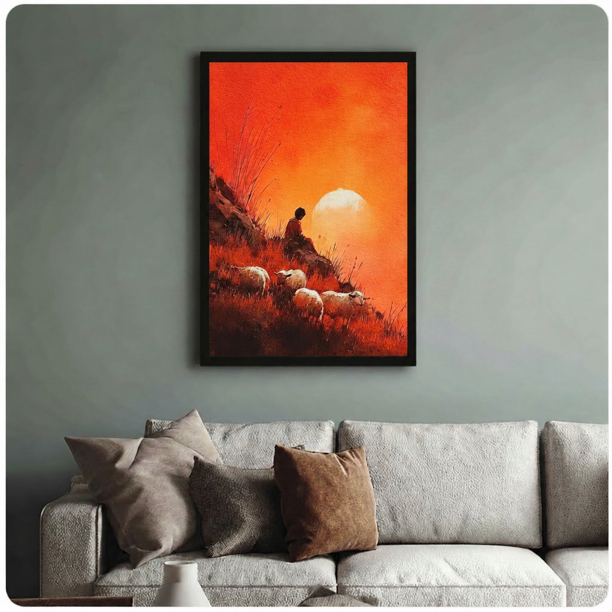 Framed shepherd sheep sunset art print above a neutral grey sofa — warm orange pastoral wall decor