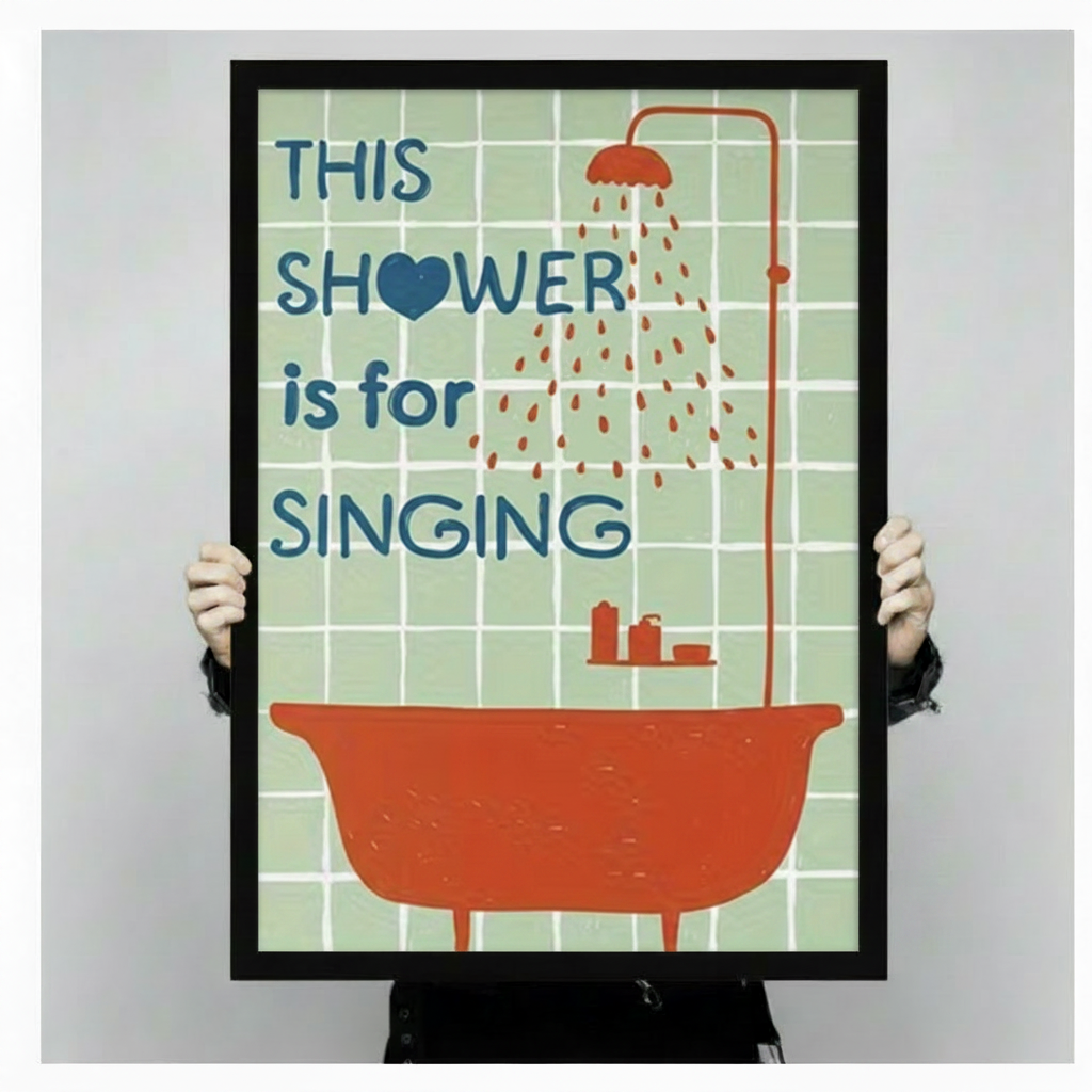 Hand-held display of a black-framed canvas art print featuring the retro "This Shower is for Singing" typography with an orange-red clawfoot bathtub and shower on a mint green tile grid — fun bathroom wall decor