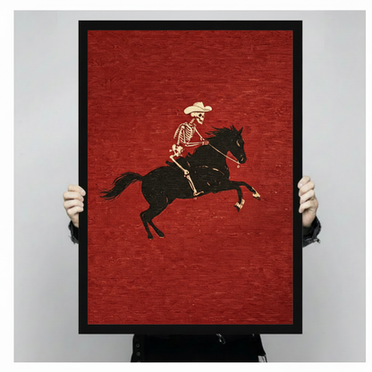 Hands holding black framed retro skeleton cowboy black horse woodcut canvas print western wall art size display