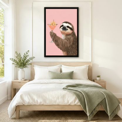 Black framed sloth holding a cocktail print displayed as bedroom wall art above a neutral linen bed in a Scandinavian-style room