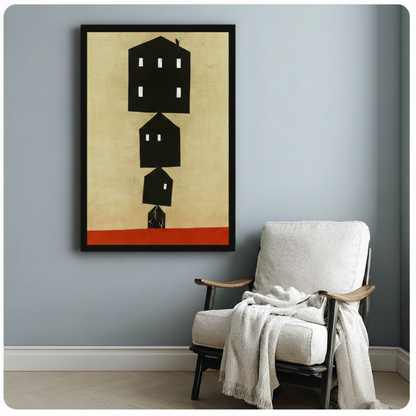 Black framed minimalist house silhouette art print with red base stripe, styled beside white linen armchair in light grey room