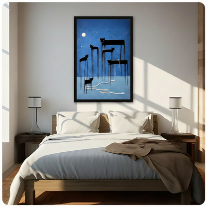 Black framed surreal black cats with long dripping legs and a white serpent under a glowing full moon canvas art hung above a wooden bed frame in a sun-drenched minimalist bedroom with crisp white linen bedding, matching cylindrical nightstand lamps, and warm natural light streaming through the window