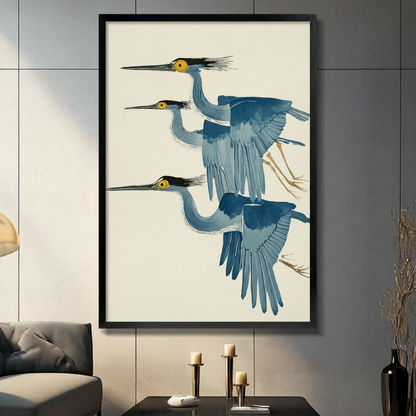 Three flying herons in Japanese ukiyo-e watercolor style framed wall art - elegant blue grey heron canvas print with golden yellow eyes black crests and warm cream background for living room decor