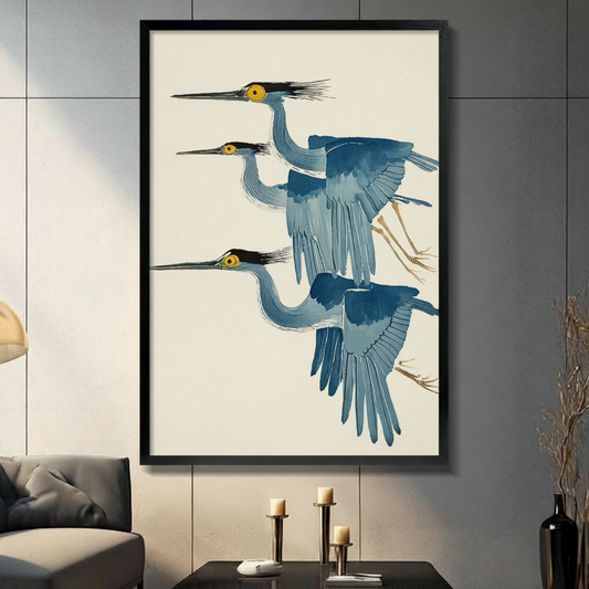 Three flying herons in Japanese ukiyo-e watercolor style framed wall art - elegant blue grey heron canvas print with golden yellow eyes black crests and warm cream background for living room decor