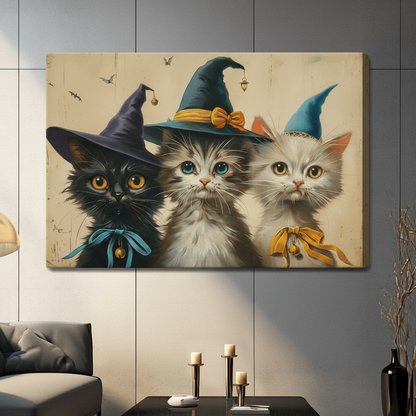 Whimsical vintage Halloween art print of three kittens in witch hats a fluffy black cat with a purple hat and teal ribbon bow a gray tabby with a teal pointed hat and gold bow and a white kitten with a small blue hat and orange ribbon with bell on a aged beige background with tiny flying bats cute Halloween cat stretched canvas in a living room with dark gray sofa and black vase