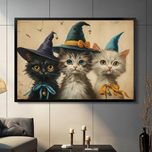 Vintage Halloween illustration of three cute kittens wearing witch hats a black cat with a dark purple hat and blue bow a gray-white cat with a teal hat and gold bow and a white cat with a light blue hat and orange bow on a distressed beige background with scattered bats cute Halloween witch cat wall art framed print in a living room with dark gray sofa candle holders and black vase