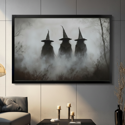 Framed gothic wall art print of three shadowy witches in tall pointed hats emerging from dense fog in a bare winter forest, displayed in a moody living room