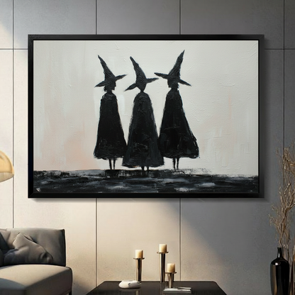 Framed black and white oil painting wall art of three witch silhouettes in pointed hats and dark cloaks standing together, displayed on a grey panelled wall in a moody modern living room