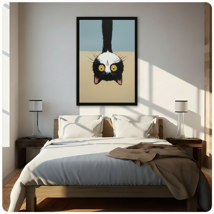 Funny tuxedo cat upside-down framed wall art above bed in bright Scandinavian-style bedroom, warm natural light with wooden nightstands and minimalist table lamps