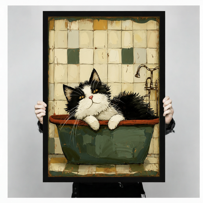 Person holding a black framed canvas print of a whimsical tuxedo cat lounging in a vintage green bathtub, showing print size and frame quality