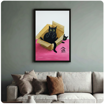 Whimsical oil painting of two black cats with bright green eyes sharing a cardboard box on a vivid pink surface, black framed print above beige fabric sofa in sage green living room