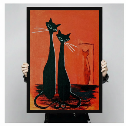 Mid-century modern graphic oil painting of two tall slender black cats with pointed ears teal eyes and white whiskers seated side by side with intertwined tails and a small orange cat silhouette in a rectangular frame behind them against a vivid orange-red background bold retro cat wall art framed print held against a light gray background