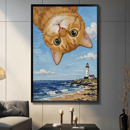 Upside down orange cat lighthouse canvas art in black frame above gray sofa — whimsical coastal wall decor