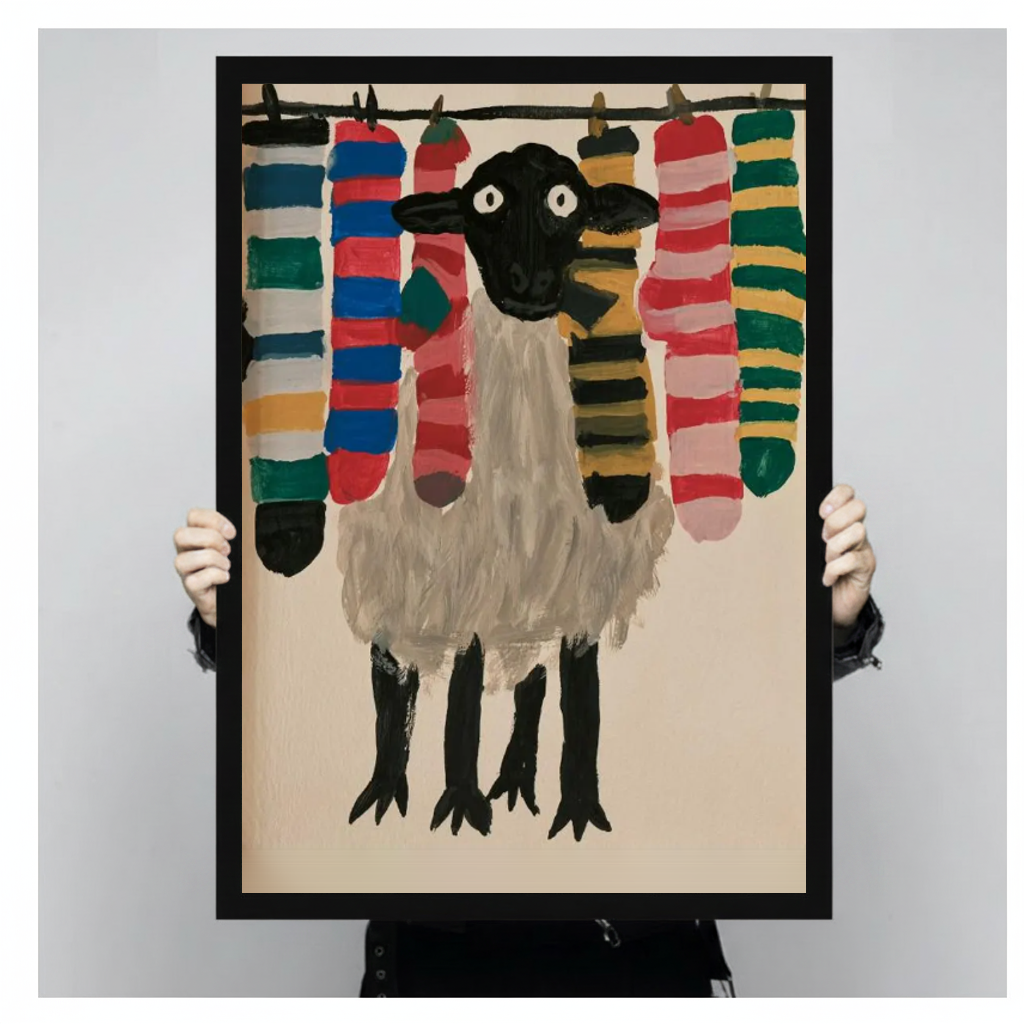 Sheep with colorful socks black framed canvas held by a person for a closer view.