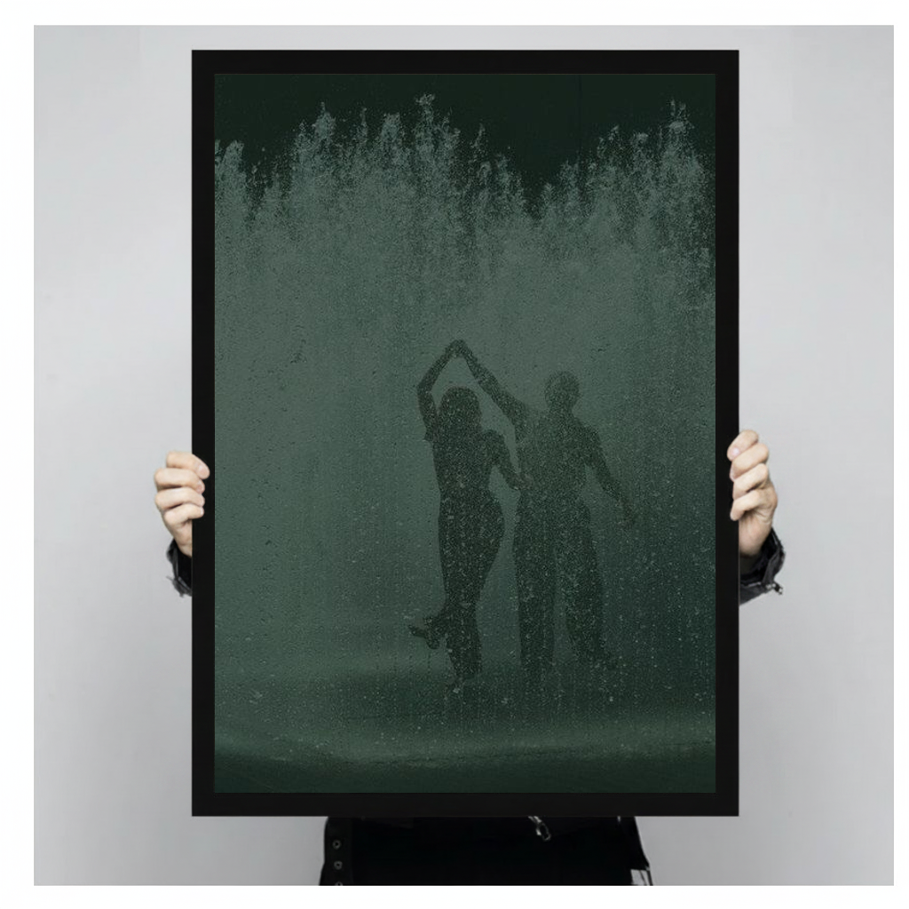 Dancing couple in green fountain spray in black framed canvas held by a person.