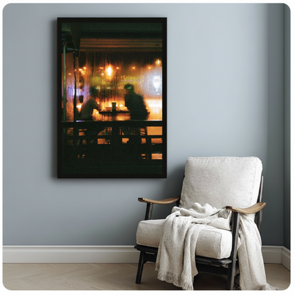 Warm cafe silhouettes behind a rainy window in framed canvas beside a light armchair.