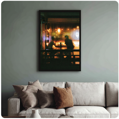 Warm cafe silhouettes behind a rainy window in framed canvas above a light living room sofa.