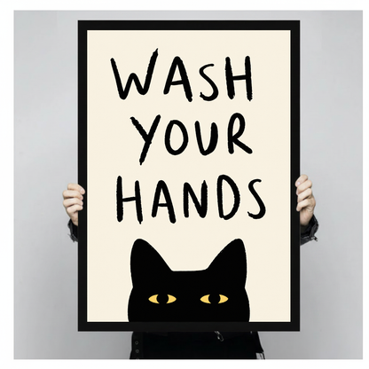 Black cat bathroom reminder with yellow eyes in black framed canvas held by a person.