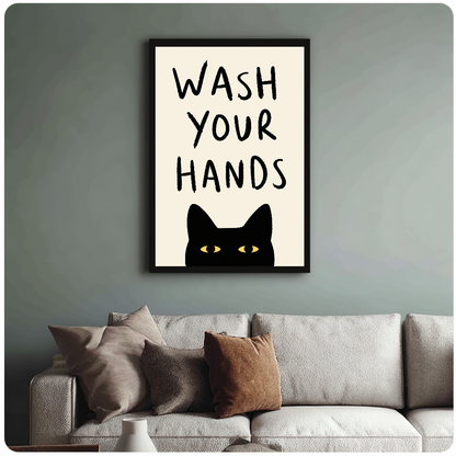 Black cat bathroom reminder with yellow eyes in framed canvas above a light living room sofa.
