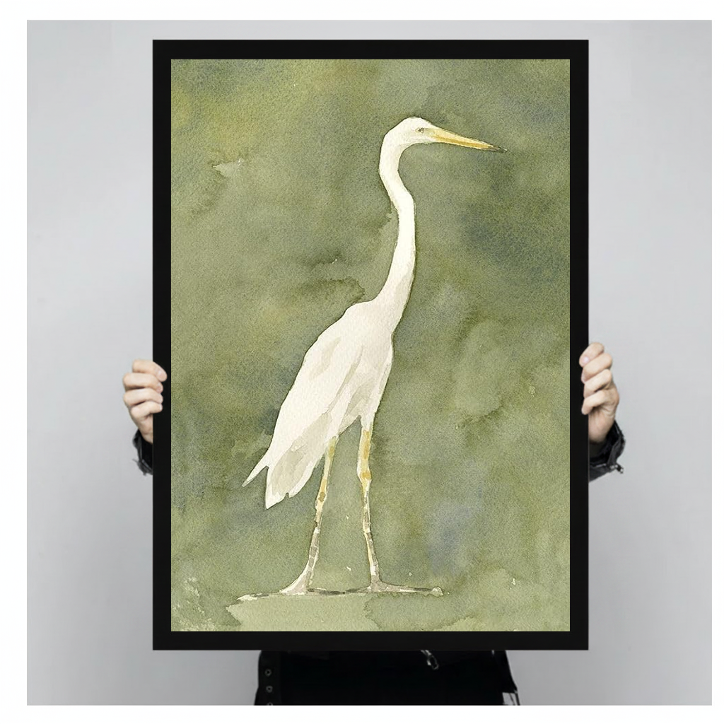 White heron watercolor on an olive background in black framed canvas held by a person.
