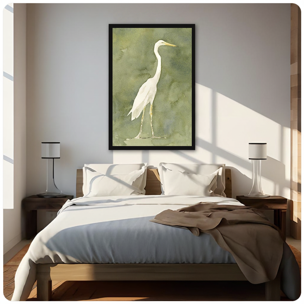 White heron watercolor on an olive background displayed as framed canvas above a neutral bed.