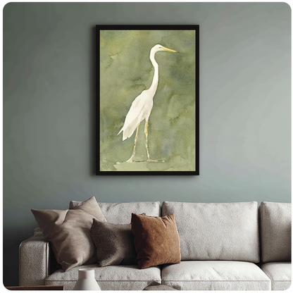 White heron watercolor on an olive background in framed canvas above a light living room sofa.