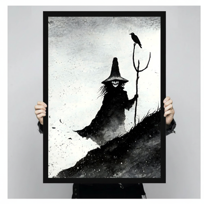 Monochrome witch with staff and perched crow in black framed canvas held by a person.