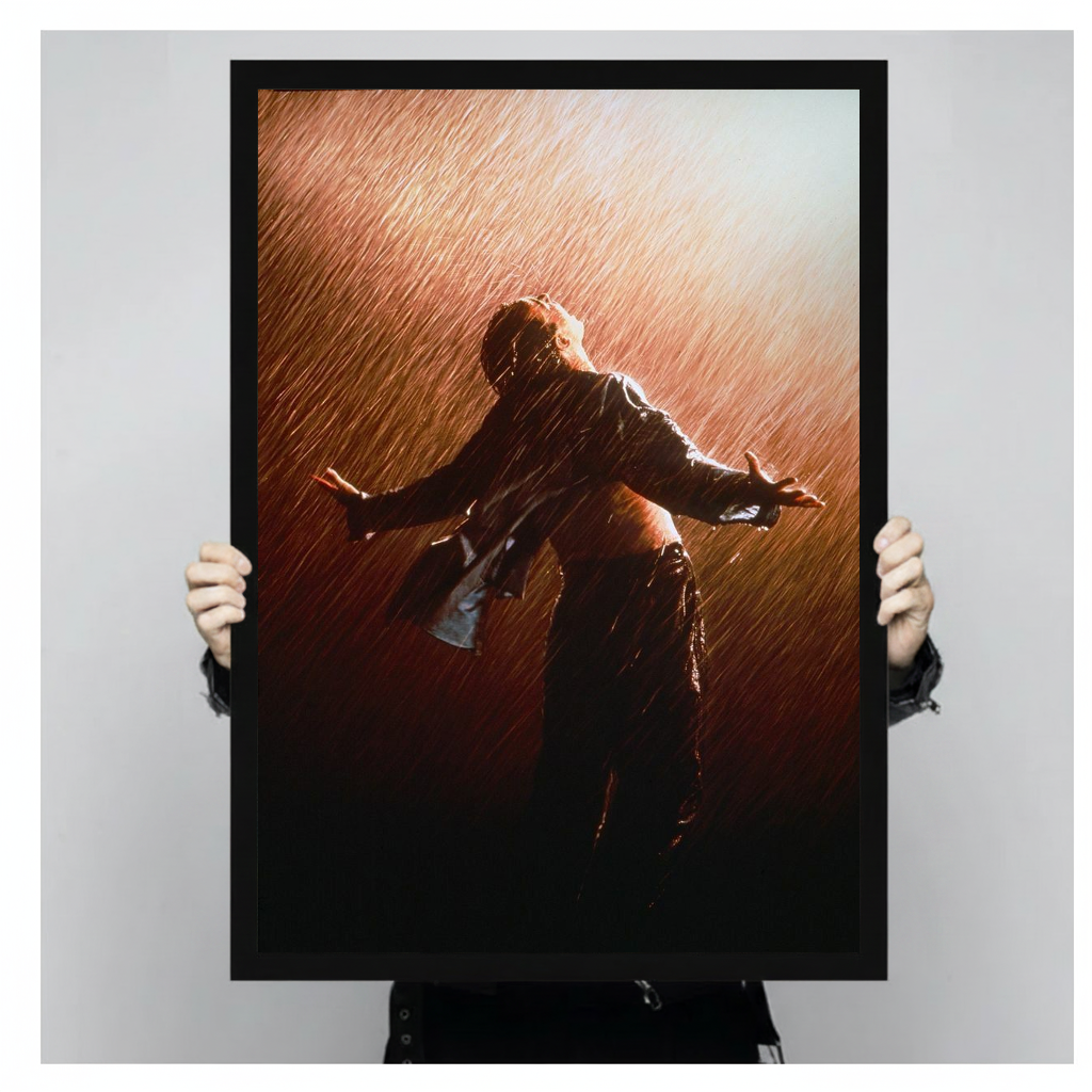 Figure with open arms in warm backlit rain in black framed canvas held by a person.