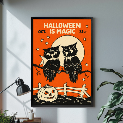 Two owls with moon and Halloween lettering displayed in black framed canvas beside a lamp.