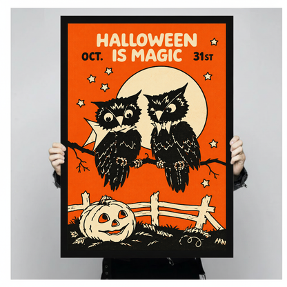 Two owls with moon and Halloween lettering in black framed canvas held by a person.