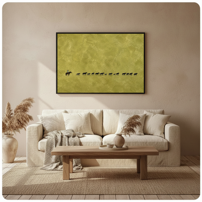 Framed cowboy and cattle trail wall art displayed above a neutral sofa with soft cushions.